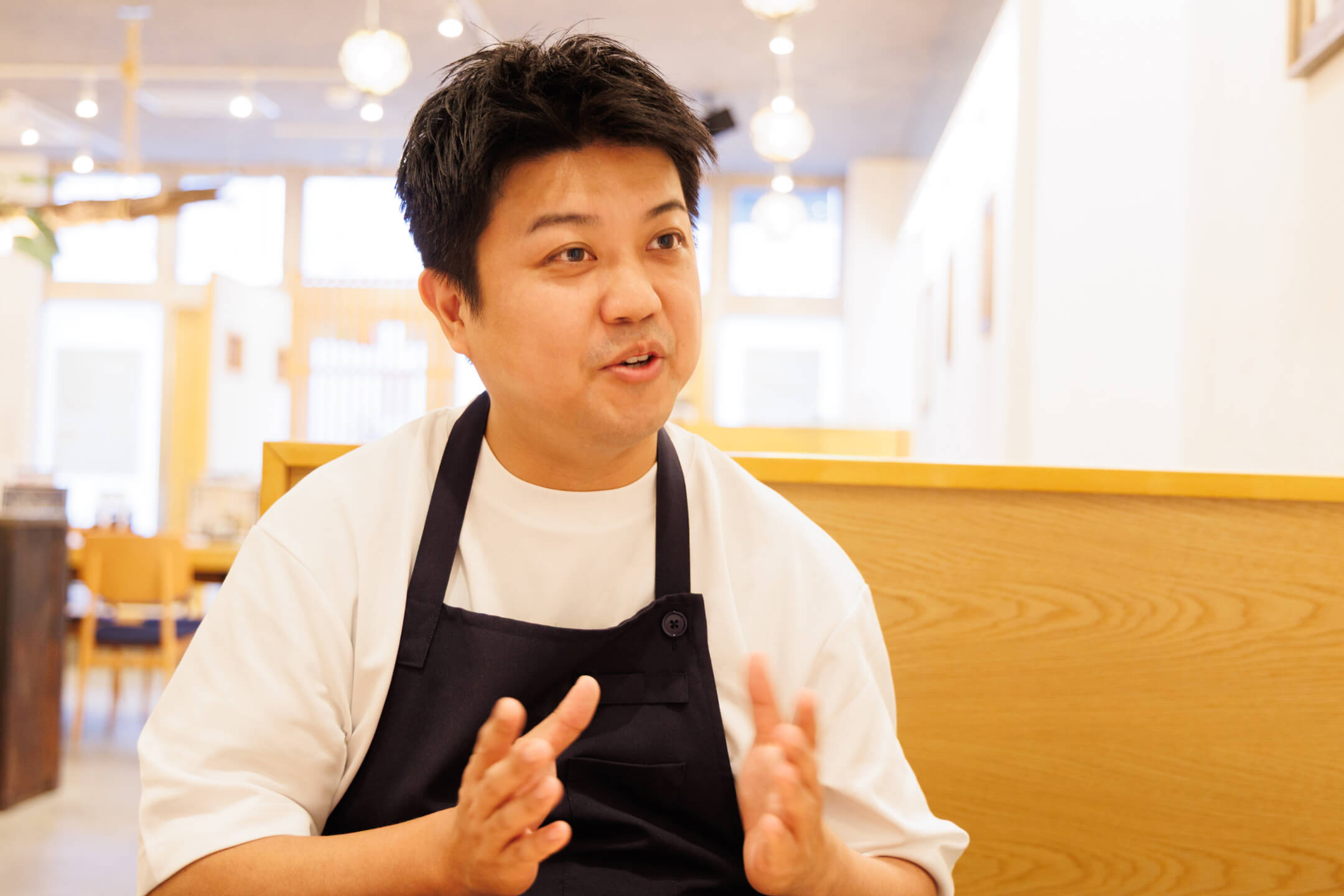 インタビューに応じ、身振り手振りを交えて和やかに談笑する様子